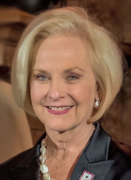 Cindy McCain in a black coat smiles at the camera.
